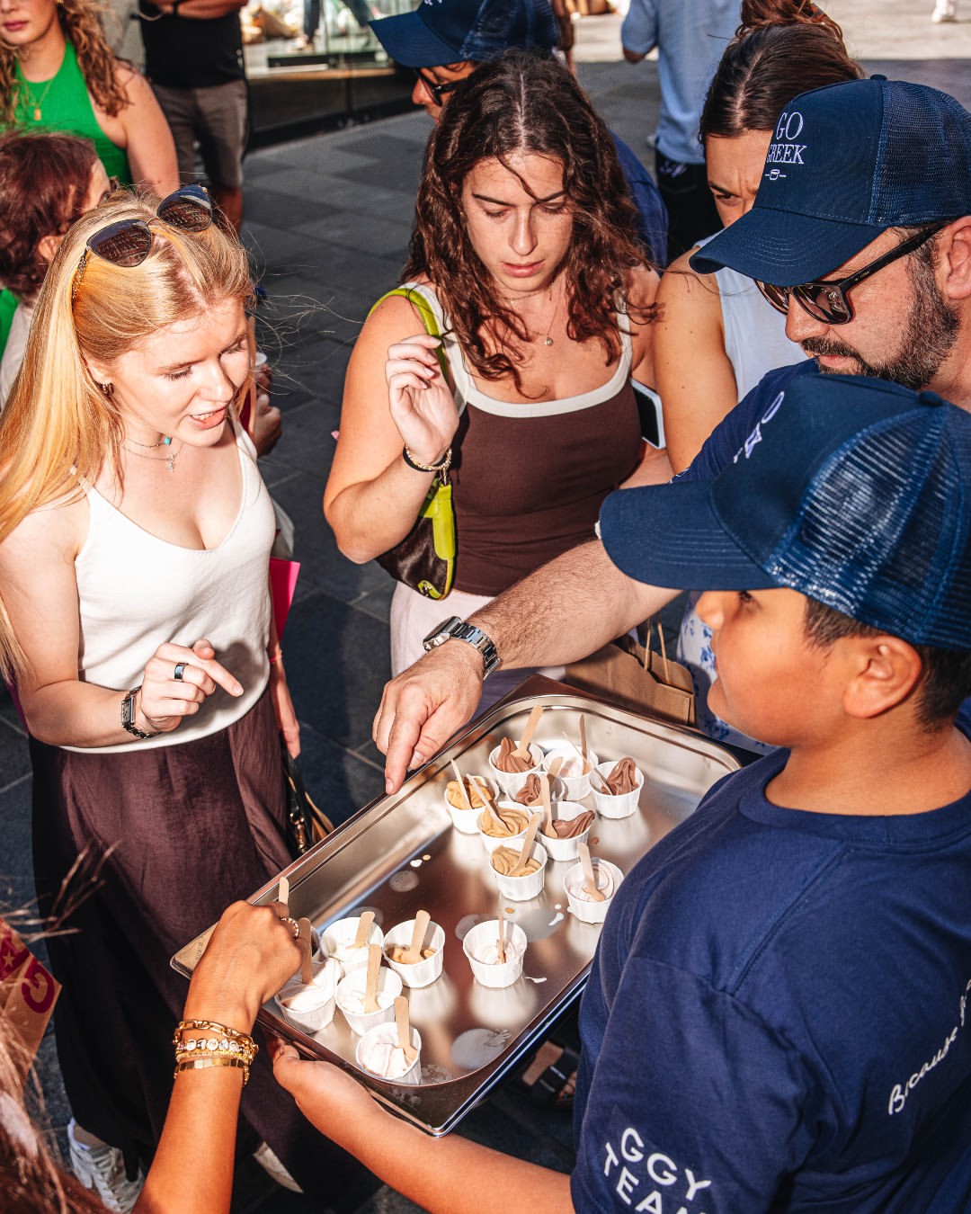 Go Greek Yogurt team handing out samples of frozen yoghurt to a crowd on South Molton Street during the London launch